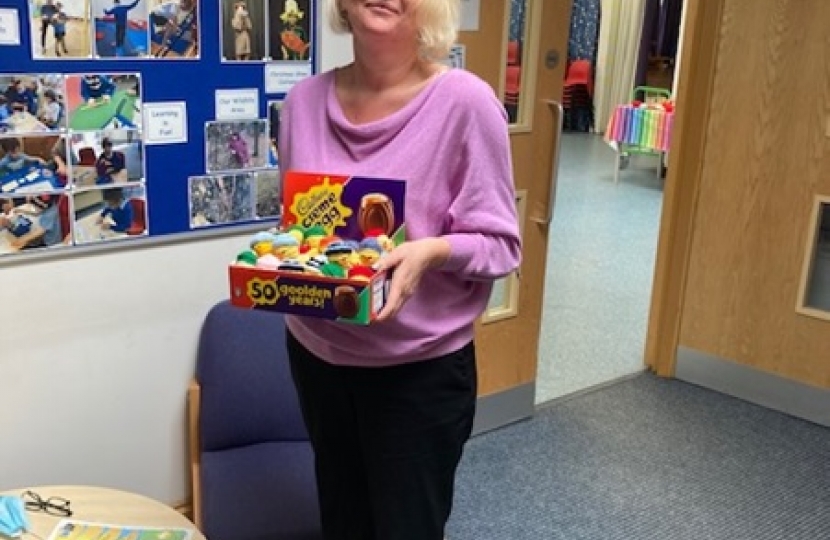 Headteacher Lisa Hall holding Sir Oliver's donated box of Charlie Chicks creme eggs