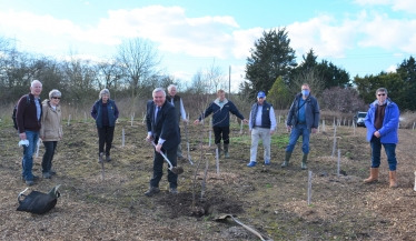 Sir Oliver putting the finishing touches to the planting with Baldock Rotary members.